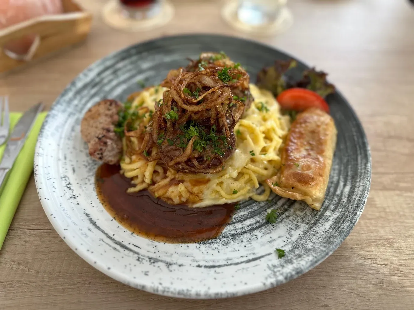 Schwäbische Vier-Jahreszeiten: Teller mit Spätzle, Röstzwiebeln, Maultasche, Fleischküchle und Bratensoße im Gasthaus Löwen